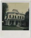 Two-story house with a cupola and an overhanging porch.  Gift of the Richard Welling Family, 20 ...