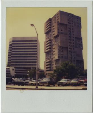 Brutalist apartment building with cantilevered balconies next to modern high-rise.  Gift of the ...