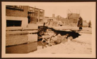 Man Looking at Part of the Street Washed Away