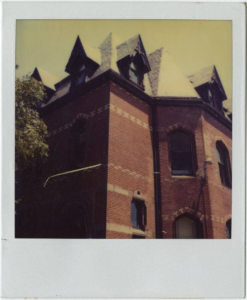 Red brick building with multiple peaked roofs and dormer windows.  Gift of the Richard Welling …