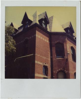Red brick building with multiple peaked roofs and dormer windows.  Gift of the Richard Welling …