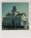 Three-story house with several peaked roofs and a mansard roof tower.  Gift of the Richard Well…