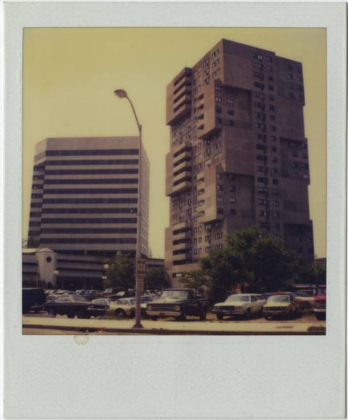 Brutalist apartment building with cantilevered balconies next to modern high-rise.  Gift of the…