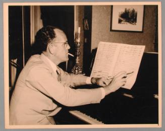 George Heck at a Piano Marking a Score