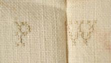 Cross-stitched initials "P W"